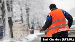 "Тазалык" ишканасынын жумушчусу чоң жолдун боюнда кар күрөп жатат. Бишкек. Иллюстрациялык сүрөт.