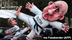 Alekszej Navalnij orosz ellenzéki vezetőt és Vlagyimir Putyin orosz elnököt ábrázoló bábuk egy düsseldorfi karneváli felvonuláson Németországban 2021. február 15-én