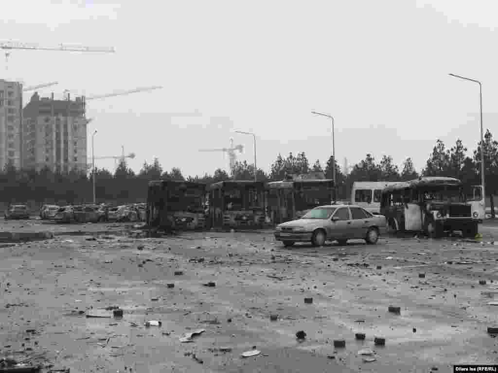Түнгі оқиғалардан кейін қала әкімдігі алдындағы алаңда шашылып жатқан заттар мен жанып кеткен көліктердің қаңқасы. Шымкент, 6 қаңтар 2022 ж.