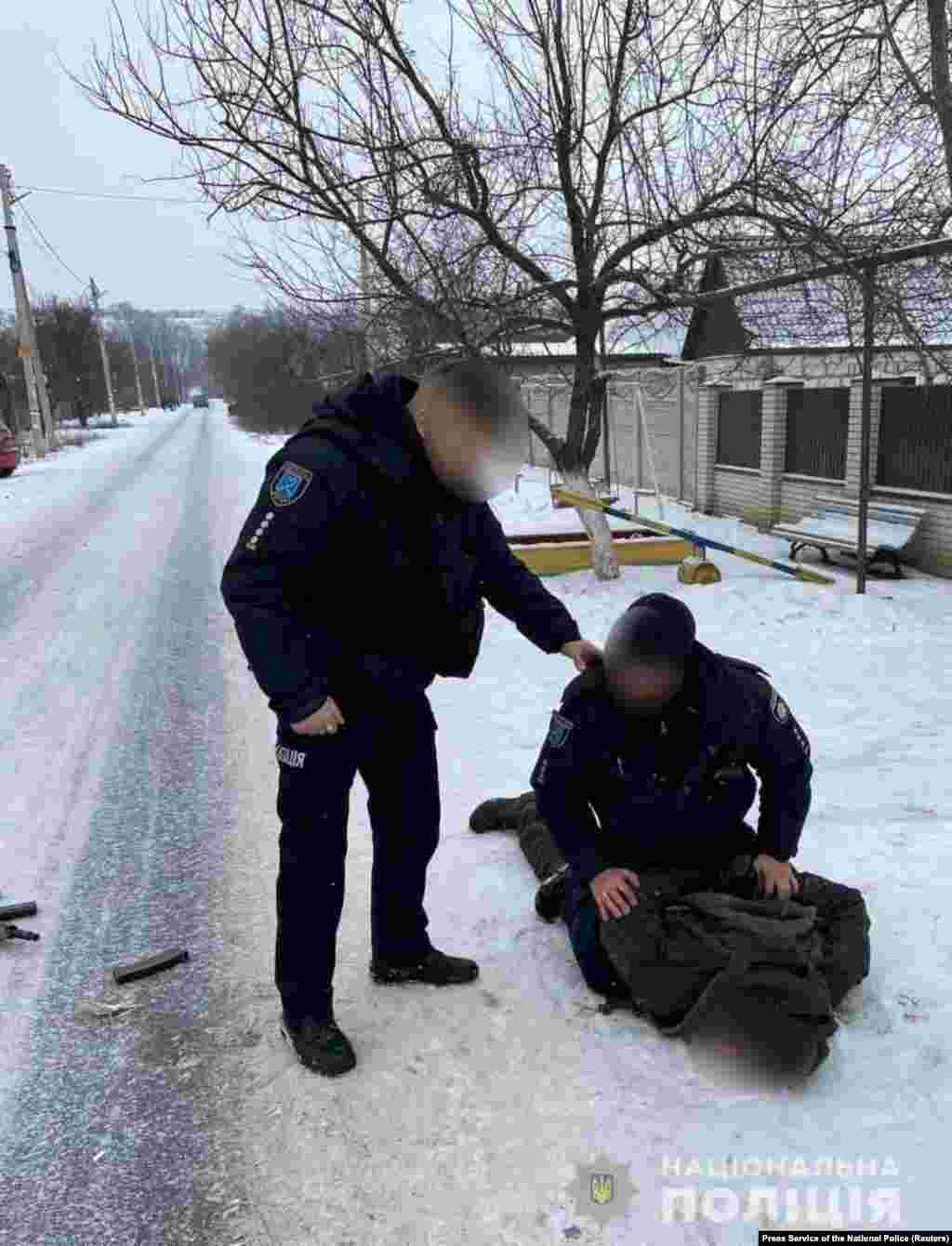Ukrainian police detain a National Guard soldier after he allegedly gunned down five people at a military factory in the Dnipropetrovsk region on January 27.&nbsp;