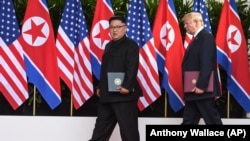Лідер КНДР Кім Чен Ин (ліворуч) та президент США Дональд Трамп після підписання документа за результатами саміту в Сінгапурі, 12 червня 2018 року