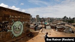 Dječak ispred grafita koji promiče borbu protiv korona virusa (COVID-19) u sirotinjskim četvrtima Mathare u Nairobiju, Kenija, 22. maja 2020.