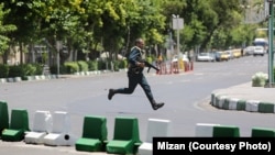 A Revolutionary Guard moves during the attack on parliament in the center Tehran June 7.
