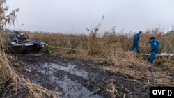 A vízügy munkatársai tisztítják az olajjal szennyezett területet Szigetszentmiklósnál 2020. december 13-án. Fotó: OVF