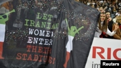 Spectators hold up a banner during an international friendly soccer match between Sweden and Iran in Stockholm on March 31.