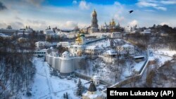 O pasăre zboară deasupra Mânăstirei Peșterilor veche de 1000 de ani acoperită cu zăpadă pe 15 ianuarie 2021