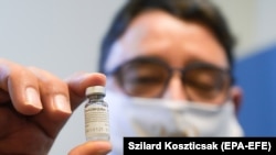 Az orosz Szputnik V vakcinát tartalmazó injekciós üveget mutat a Semmelweis Egyetem rektora, Merkely Béla, miután beoltották az egyetem oltópontján 2021. február 18-án