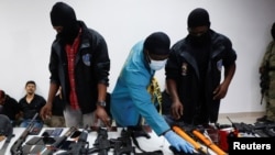 Elfogott merénylők és fegyvereik Port-au-Prince-ben, 2021. július 8-án.