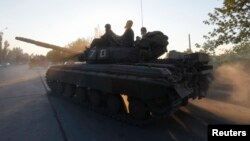 Ukrainian servicemen ride a tank in the southern coastal town of Mariupol on September 5.