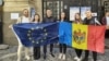 Moldovan citizens in Romania hold European and Moldovan flags at a diaspora polling site in Bucharest.