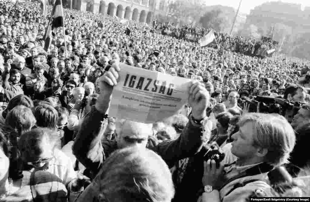 Un bărbat ține în mână un ziar care anunță că Ungaria a devenit o republică democratică, pe 23 octombrie 1989. Titlul numește acea zi drept o &bdquo;victorie așteptată, dar în niciun caz întârziată&rdquo;. Parlamentul Ungariei a aprobat în scurt timp modificarea constituției țării, deschizând astfel calea către alegeri libere. Președintele în exercițiu al țării, Matyas Szuros, a anunțat în fața unei mulțimi de mii de oameni, adunate la parlament: &bdquo;Declar solemn că, începând de astăzi, 23 octombrie 1989, Ungaria este o republică și se numește Republica Ungară&rdquo;. &nbsp; &nbsp;