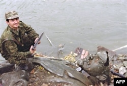 Чеченський міліціонер сідить на поваленій статуї російського більшовицького вождя Леніна. Грозний, Чечня. 25 жовтня 1991 року