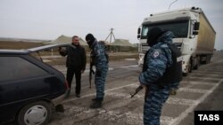 Miliții pro-ruse la punctul de control Cingar pe o șosea spre Crimea, 9 martie 2014.