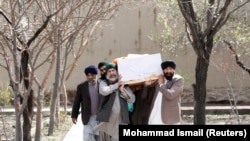 Afghan Sikh men carry a coffin of one of the victims who was killed during a March 25 attack on Sikh religious complex in Kabul.