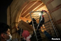 Protestuesit propalestinez duke vendosur barrikada në UCLA më 1 maj 2024.