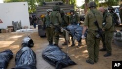 ისრაელის არმიის სამხედროებს გამოაქვთ კიბუც კფარ-აზაზე „ჰამასის“ თავდასხმისას მოკლულთა გვამები. 2023 წლის 10 ოქტომბერი