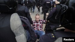 Полицейские несут задержанного на акции протеста в Петербурге. 12 июня 2017 года.