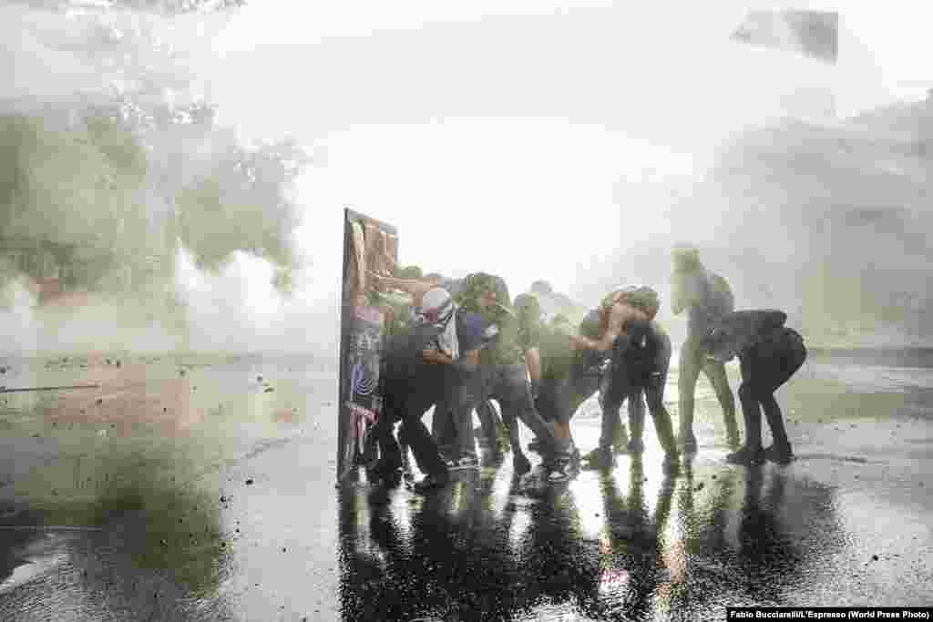 Демонстранти захищаються щитом від водометів під час сутичок у Сантьяго, Чилі, 28 листопада 2019 року. Друге місце в категорії &laquo;Загальні новини&raquo;, історії&nbsp;&ndash; Фабіо Буччареллі, L&#39;Espresso