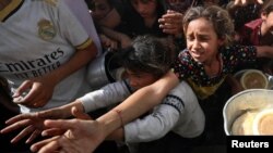 Fëmijët palestinezë presin të marrin ushqim të gatuar nga një kuzhinë bamirësie, në Beit Lahia, në veri të Rripit të Gazës, 3 prill 2025.