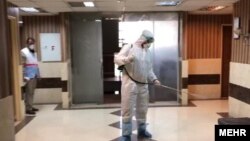 FILE: Health workers disinfect a building in Iran to prevent the spread of coronavirus.