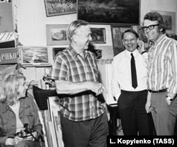 Художник Микола Глущенко (ліворуч) у своїй майстерні в Києві, 1972 рік. Як зазначено в описі світлини фотоагентства, на зустрічі з українським художником: ректор Вищої школи образотворчих мистецтв в Гамбурзі (Німеччина) Герберт фон Буттлер, кореспондент газети «Гамбургер морген пост» Регіна Кольруш і депутат гамбурзького ландтагу Герхард Вебер