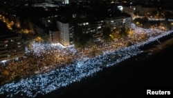 Okupljeni sa upaljenim svetlima mobilnih telefona tokom 16 minuta tišine, tokom obeležavanja prve godišnjice kobnog urušavanja nadstrešnice železničke stanice u Novom Sadu u novembru 2024. godine, u kojem je poginulo 16 ljudi