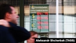Прохожие рядом с пунктом обмена валют в Москве. 8 августа 2018 года.