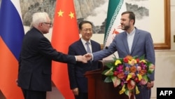 Слева направо: заместитель министра иностранных дел России Сергей Рябков, исполнительный вице-министр иностранных дел Китая Ма Чжаосюй и заместитель министра иностранных дел Ирана Казем Гарибабади проводят пресс-конференцию в Пекине, 14 марта 2025 года