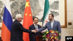 Зліва направо: заступник міністра закордонних справ Росії Сергій Рябков, виконавчий віцеміністр закордонних справ Китаю Ма Чжаосюй та заступник міністра закордонних справ Ірану Казем Гарібабаді проводять пресконференцію у Пекіні, 14 березня 2025 року