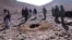 A RFE/RL video grab shows Afghan men stoning Afghan woman Rokhsana (C, in hole) to death in Ghalmeen, Afghanistan's Ghor province. Local officials say the incident happened in October. 