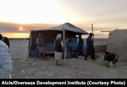 Afgánok pihennek Dakban, a pakisztáni határon, mielőtt Balucsisztánon keresztül az iráni–pakisztáni határra indulnának 2021 márciusában