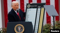 АҚШ президенті Дональд Трамп шетелден келетін тауар түрлеріне баж салығын салу туралы кестені көрсетіп тұр. Ақ үй, Вашингтон, 2 сәуір, 2025 жыл.