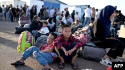 گروهی از افغان‌هایی که از ایران اخراج شده و در گذرگاه مرزی اسلام‌قلعه منتظر ورود به خاک افغانستان هستند