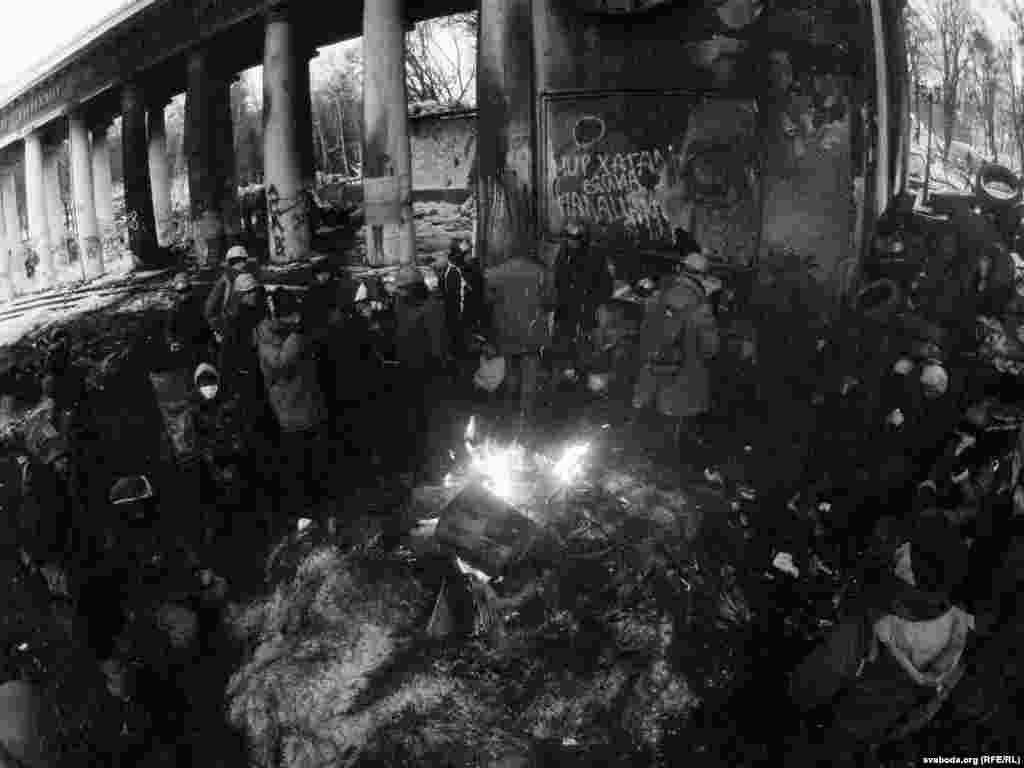 Protestuesit që përpiqen të ngrohen rreth një zjarri.&nbsp;