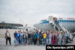 „Csernobili gyerekek” pózolnak egy belarusz gép előtt a hannoveri reptéren, 2018. május 30-án