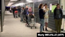 Vásárlók várják a sorukat egy wellingtoni élelmiszerbolt előtt, 2020. augusztus 11.