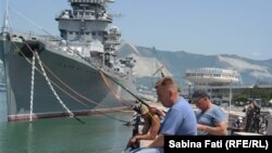 Novorossisk, Rusia 2016: Pescari lîngă crucișătorul Mihail Kutuzov