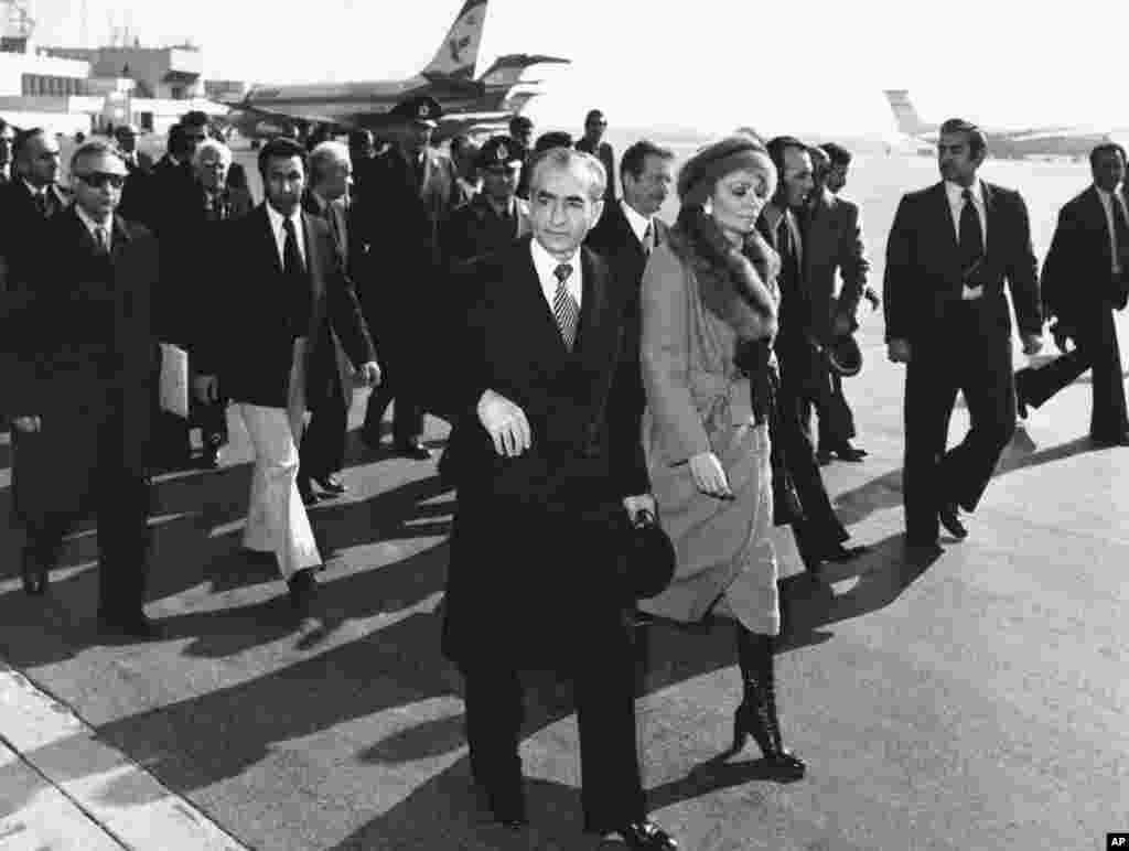 Na ovoj fotografiji iz januara 1979., šah Pahlavi i carica Farah hodaju asfaltom na aerodromu Mehrabad u Teheranu kako bi se ukrcali u avion i napustili Iran.