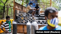 Katër indianë afër bombolave të oksigjenit.