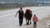 KAZAKHSTAN -- A woman and a child walk with a cow along a street during a lockdown imposed by the government as part of state of emergency to prevent the spread of the coronavirus disease (COVID-19) in Almaty, April 14, 2020