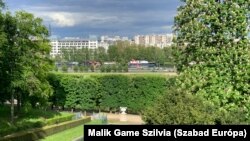 Gesztenyefákkal tarkított látkép: háttérben a Szajna lakóhajói, az OECD kupolás épülete és az Eiffel-torony.