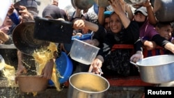 Palestinezë të mbledhur për të marrë ushqim nga një kuzhinë bamirësie, mes një krize urie, në Qytetin e Gazës, më 24 korrik 2025. 