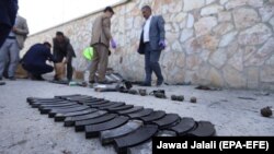 Afghan security officials inspect the scene of an attack by militants outside the Interior Ministry building in Kabul on May 30