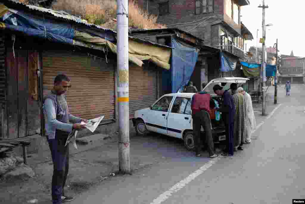 Një burrë lexon gazetën ndërsa të tjerët blejnë perime.&nbsp;Pakistani ka hedhur poshtë mundësinë e përgjigjes ushtarake ndaj vendimit të Indisë për t&rsquo;i hequr statusin special rajonit të Kashmirit.