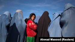 Kabul - Avganistanska djevojčica stoji među udovicama u burkama, 6. januar 2010.