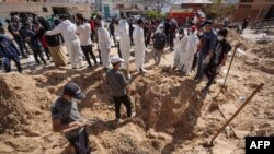 Газадагы Саламаттык сактоо башкармалыгынын өкүлдөрү Насер ооруканасынын короосунда адам сөөктөрү жапырт көмүлгөн жайды казып жатышат. 21-апрель, 2024-жыл. Хан-Юнис шаары.