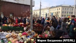 ​До торгового центру «Зимова вишня», де сталася пожежа, люди несуть квіти та іграшки, запалюють свічки, 26 березня 2018 року