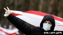 Lukasenka lemondását követelő tüntető zászlóval Minszkben 2020. december 13-án
