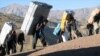 Bent under the weight of their loads -- smuggled cigarettes, alcohol, gasoline, and even home appliances -- the "mules" are a common sight in Iran's western border regions.