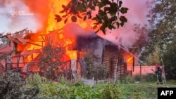 آتش‌نشان اوکراینی در حال مهار آتش پس از حمله هوایی تازۀ روسیه به لِویو